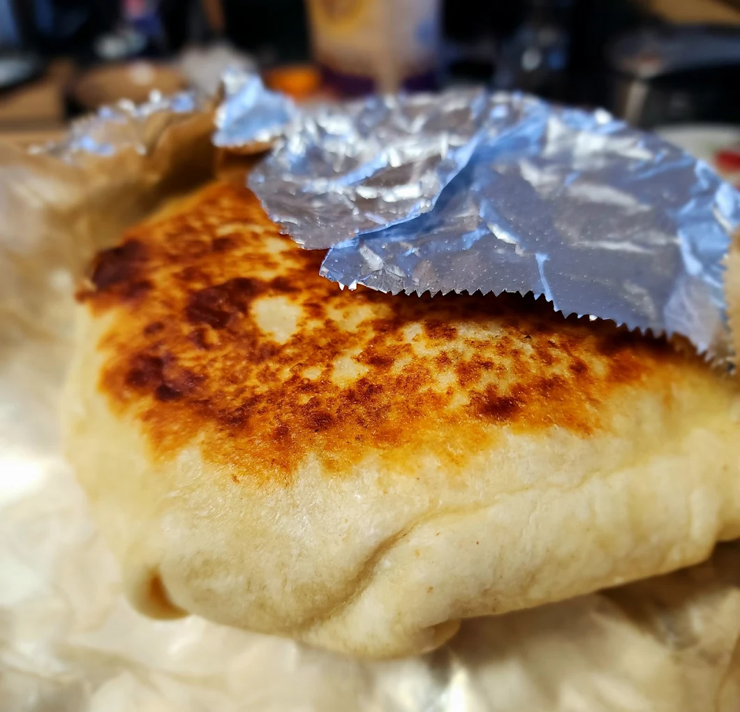 Griddled burrito wrapped in foil from the Fronteras Taqueria window